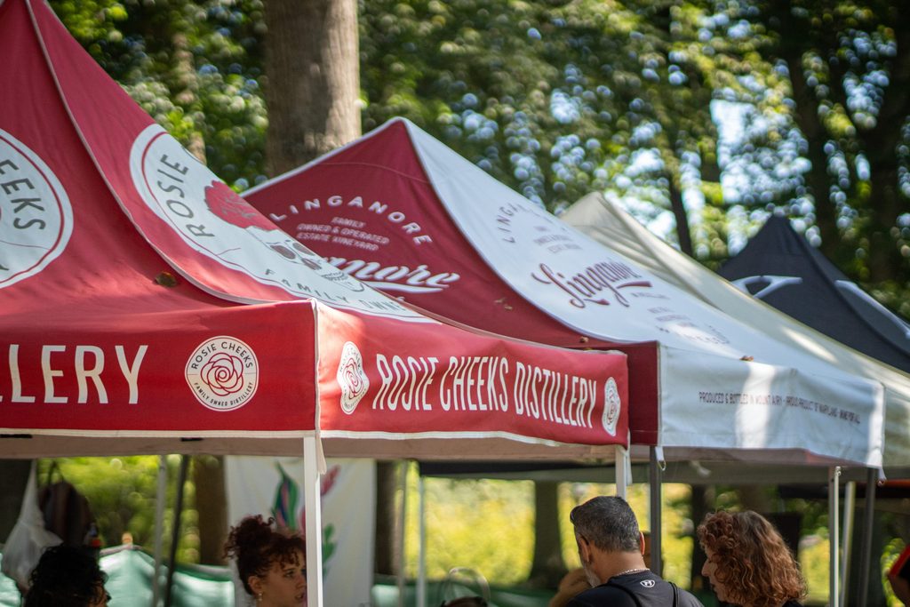 Rosie Cheeks Distillery and Linganore Winecellars branded vendor tents set up at an outdoor event.